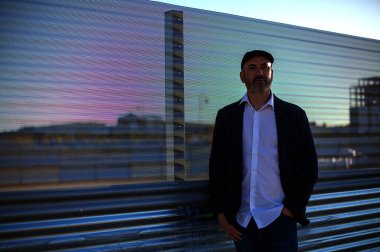 Zarif, olgun bir adam sakin ve düşünceli bakışları sanayi şehri ortamında kaybolmuş.