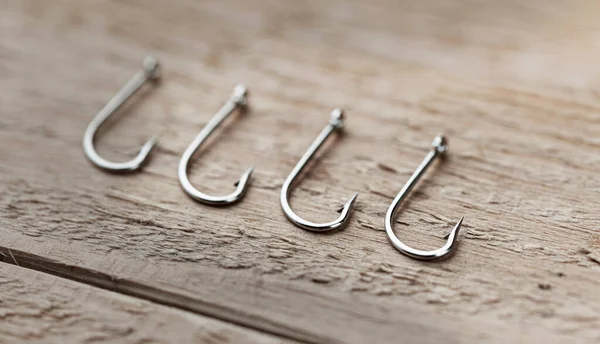 Fishing hooks on a wooden board. Close-up of a fishing hook. Blurred concept