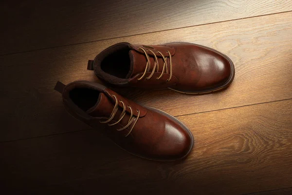 Brown leather boots, mens brown ankle boots, isolated on a wooden background