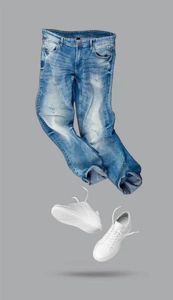 Μπλε Τζιν Λευκά Δερμάτινα Αθλητικά Παπούτσια Γκρι Φόντο Επώνυμα Ρούχα — Φωτογραφία Αρχείου