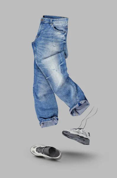 蓝色牛仔裤 白色皮鞋孤立在灰色背景 有品牌的衣服 模仿你的设计 有快捷方式 — 图库照片