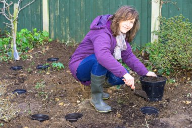 Planting bulbs in plantpots buried in clay soil helps prevent them from rotting.  The technique also aid future lifting, splitting and reduces the impact of weeds.