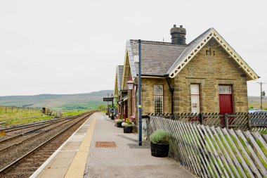Ribblehead Tren İstasyonu hala Settle ve Carlisle Hattı için aktif olarak kullanılıyor. Ribblehead, Carnforth, Yorkshire Dales Ulusal Parkı, 1 Haziran 2023.
