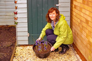 Çekici ve olgun bir esmer bayanı, çiçeklerle Iris ampullerinin tadını çıkarırken yakalıyorum..