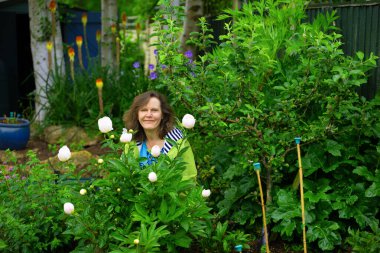 Mutlu ve çekici bir kadın bahçıvan, Mayıs 'ın sonlarında yaz ekimi hazırlıklarını gururla gösterir..