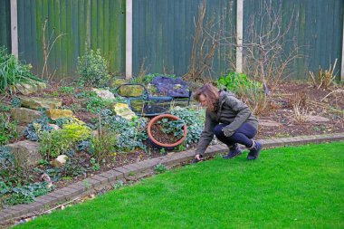 Elle tutulan çim makası kullanarak olgun esmer bir kadın yakalamak..