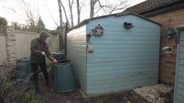 Gelecek bahar için gübreyi teslim eden olgun, sağlıklı, esmer bir bahçıvan yakaladım..