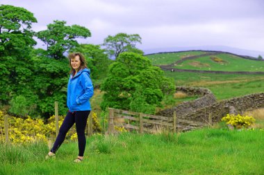 Çekici ve mutlu bir bayanı, kamp hazırlıklarını tamamlamak üzere Skipton, North Yorkshire, İngiltere 'deki Draughton Heights' ın muhteşem manzarasının tadını çıkarmak için yakalıyorum..