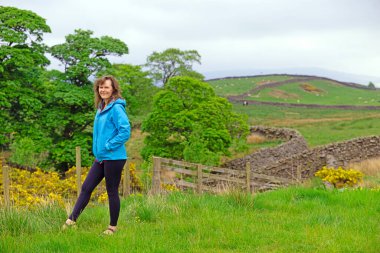 Çekici ve mutlu bir bayanı, kamp hazırlıklarını tamamlamak üzere Skipton, North Yorkshire, İngiltere 'deki Draughton Heights' ın muhteşem manzarasının tadını çıkarmak için yakalıyorum..