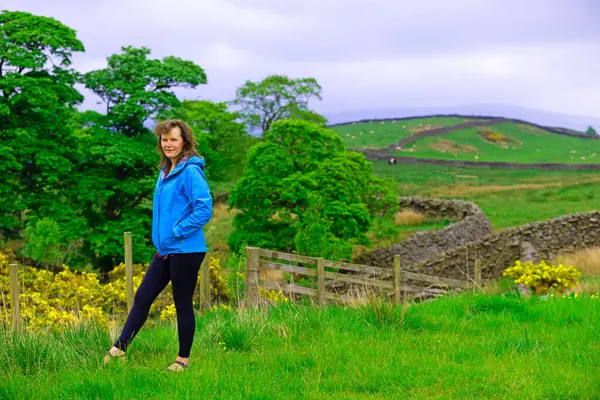 Çekici ve mutlu bir bayanı, kamp hazırlıklarını tamamlamak üzere Skipton, North Yorkshire, İngiltere 'deki Draughton Heights' ın muhteşem manzarasının tadını çıkarmak için yakalıyorum..
