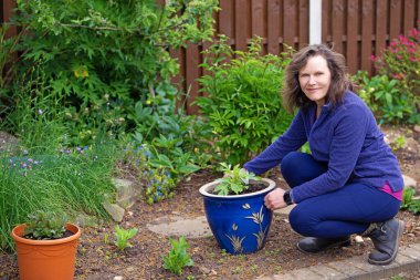 Çekici bir esmer, saksıda poz veriyor..
