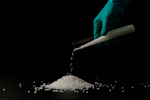 Крупный план пластиковых полимерных гранул. держат полимерные гранулы. Полимерный пластик. составной полимер. Био-пластик. 