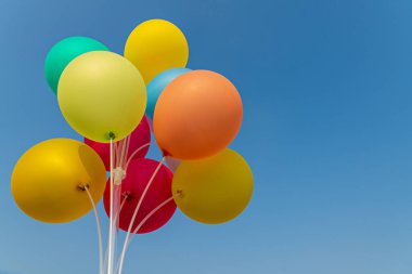 Arka planda çok renkli balonlar. Blue Sky arka planında renkli balonlar. Doğum günü, kutlama ve parti dekorasyonu konsepti. Düğün balayı partisi konsepti.