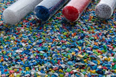 Ezilmiş küçük plastik parçaları. Geri dönüşüm için ezilmiş şişe kapakları. Plastik atıkla plastik kenar karışacak. Plastiği küçültme kavramı.