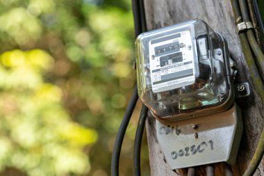 Bulanık gökyüzü arka planında kilovat saat metresi. Elektrik sayacı güç kullanımını ölçüyor. Elektrik İzleme Ekipmanı. ölçüm enerji tüketimi.
