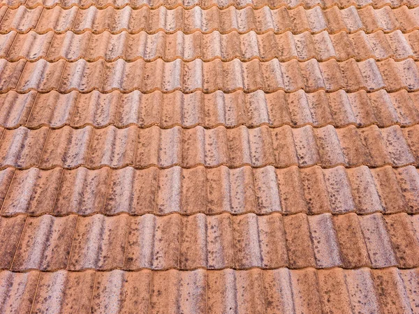 Kahverengi kil çatı kiremitlerini kapatın. Kırmızı, eski, kirli çatı. Eski çatı kiremitleri. İnşaat malzemeleri bir ev inşa ediyor..