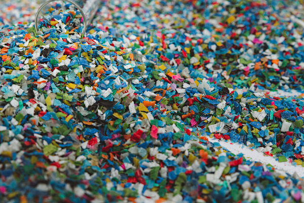 Hands hold clear white plastic pellets, raw materials for various manufacturing processes. These pellets are widely used in industries to produce products like packaging, bottles, and equipment parts. The white background highlights the pellets, maki