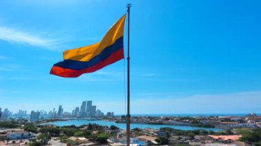 San Felipe Kalesi 'nde bayrak sallanıyor. Arkaplanda Cartagena Bocagrande silueti.