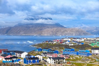 Grönland başkenti Nuuk 'un panoramik manzarası fiyort ve buzdağları yakınlarındaki renkli evlerle.