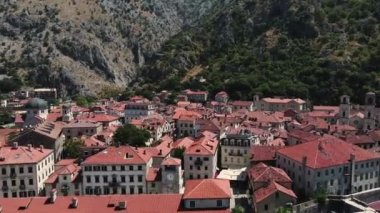Kotor Old Town, Karadağ. Sunny Summer Day 4k 'te Fort and Buildings çatılarının insansız hava görüntüsü.