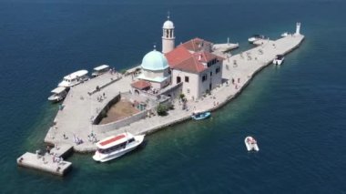 Perast, Boka Kotorska, Karadağ. Güneşli bir günde Katolik Kilisesi 'nin insansız hava görüntüsü. Kayalıkların Hanımefendisi, Eşsiz Tarihi Yer ve Mavi Adriyatik Denizi Suyu
