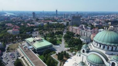 Belgrad, Sırbistan. Güneşli yaz gününde Saint Sava Tapınağı 'ndan havadan görüş, şehir manzarası ve rıhtım manzarası 4k