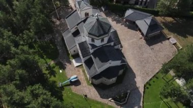 Church of Holy Transfiguration, Zlatibor Mountain, Serbia. Birdseye Aerial View of Religious Landmark in Green Pine Landscape on Sunny Day, Orbiting Top Down Drone Shot