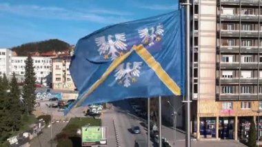 Uzice City Flag and Serbian National Flag Waving on Wind in Downtown on Sunny Day