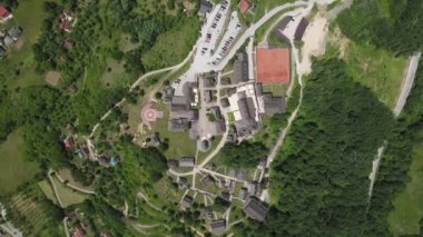 Drvengrad, Mecavnik Hill, Mokra Gora Serbia. Top Down Birdseye Drone Aerial View of Village in Green Landscape on Sunny Summer Day 4k