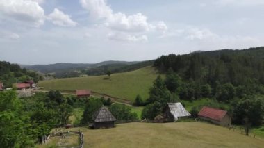 Kremna Köyü, Tara Dağı, Sırbistan. Küçük Çiftlik, Eski Ahşap Ahırlar ve Yeşil Ovalar 'ın Havadan Görüntüsü Yaz Günü, Drone Shot 4K