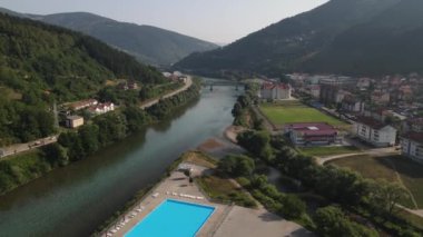 Foca Town, Bosna-Hersek 'teki Drina Nehri. Nehir kenarındaki yüzme havuzunun insansız hava görüntüsü ve 4. yaz gününde sakin manzarası.