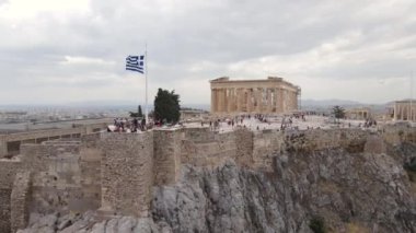 Atina, Yunanistan. Antik Akropolis 'in Hava Görüntüsü, Yunan Bayrağı ve Ünlü Tarihi Yeri Ziyaret Eden İnsanlar, İHA' yı Geri Çekin 4k