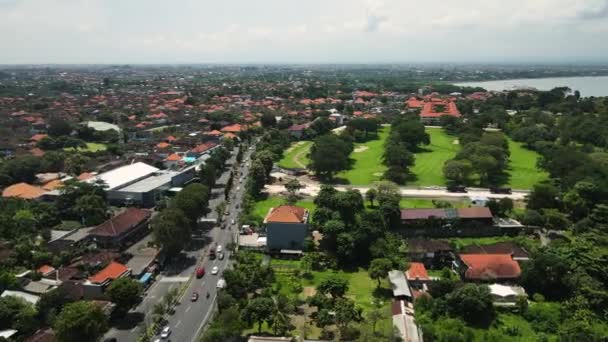 インドネシアのバリ島 サヌール 忙しいバイパス道路交通 建物や熱帯ラッシュ ドローンショット4Kの空中ビュー — ストック動画