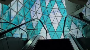 Bakü 'nün modern mimarisi, Azerbaycan. Lüks Alışveriş Merkezi 'nde Büyük Cam Duvarlar, Yürüyen merdivenden Manzara 4k