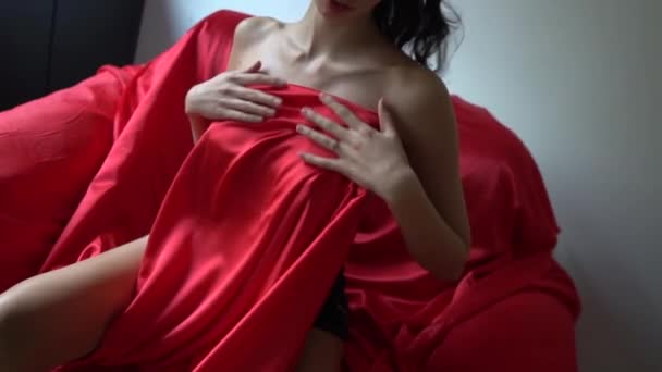 Sexy Młoda Kobieta Zakrywając Jej Ciało Czerwony Satyna Podczas Siedzi — Wideo stockowe