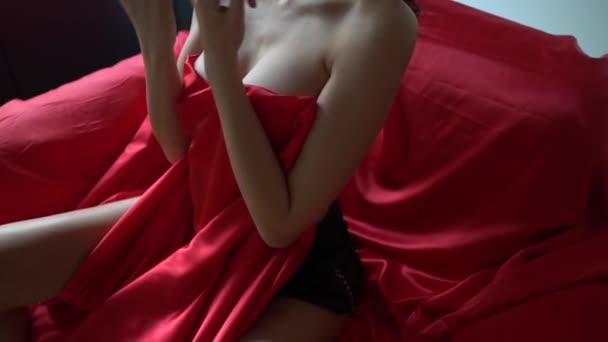 Zbliżenie Młodej Seksownej Kobiety Zakrywającej Piersi Czerwoną Satynową Tkaniną Powolny — Wideo stockowe