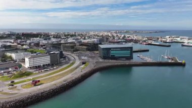 Reykjavik İzlanda. Güneşli bir günde Harpa Konser Salonu ve Şehir Limanı 'nın Hava Görüntüsü. Drone 60fps 4k 'ı vurdu.