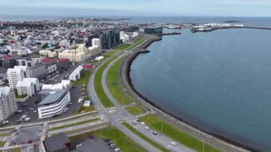 Reykjavik, İzlanda. Kıyı trafiği, liman ve modern rıhtım binalarının hava manzarası 4k