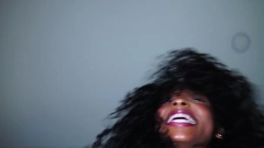 Komik kıvırcık Barbie, kamera için poz veriyor. Dili dışarıda, yavaş hareket ediyor.