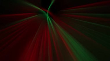 Green and red flashing beams of light are moving against a dark background. Animated background and club video. Endless cycle. A loop
