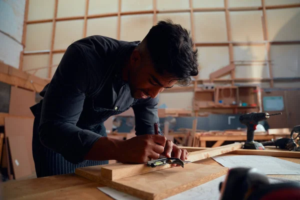 木工工場で木の上のツールを使用している間 鉛筆で書く多人種の若者 — ストック写真