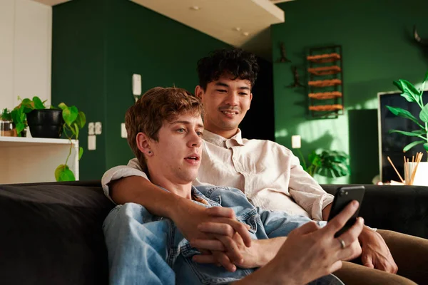 Happy Young Gay Couple Looking Mobile Phone While Holding Hands — Stock Photo, Image