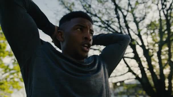 Young Black Man Sports Clothing Hands Head Exhaling Break Trees — Αρχείο Βίντεο