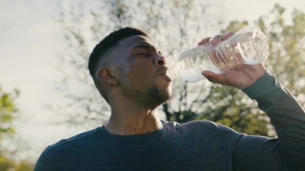 Athletic Young Black Man Sportswear Taking Break Drinking Water Trees — Stockvideo