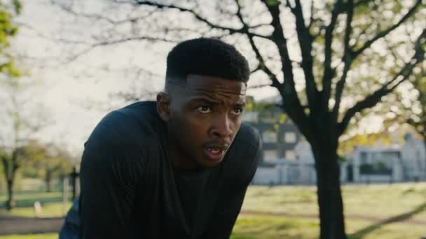 Атлетичный Черный Молодой Человек Спортивной Одежде Отдыхает После Пробежки Деревьям — стоковое видео