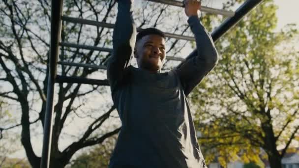 Решительный Молодой Черный Мужчина Делает Подбородок Выдыхает Обезьяньих Батончиках Парке — стоковое видео
