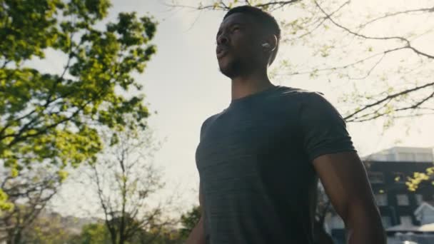 Entschlossener Junger Schwarzer Mann Mit Shirt Und Drahtlosen Kopfhörern Hebt — Stockvideo
