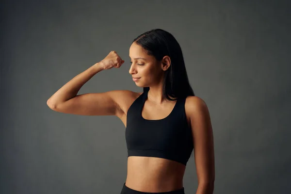 Jovem Biracial Mulher Vestindo Esportes Sutiã Flexing Bíceps Músculos Estúdio — Fotografia de Stock