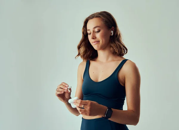 Young Caucasian Woman Wearing Fitness Tracker Looking While Holding Wireless — Stock Photo, Image
