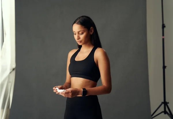Focused Biracial Young Woman Wearing Sportswear Looking While Holding Wireless —  Fotos de Stock